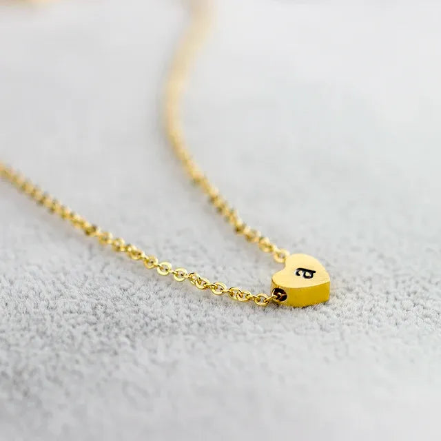 Gold heart-shaped necklace with a letter 'a' on a light gray background - Affordbale artificial jewellery in pakistan