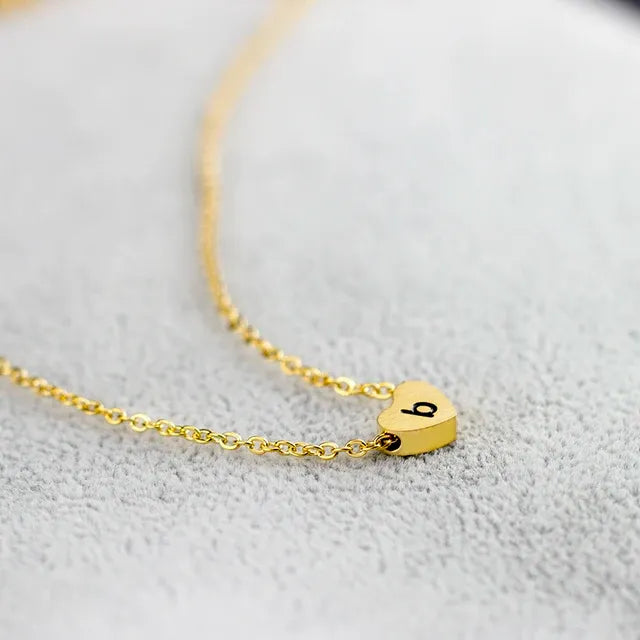 Gold necklace with a heart-shaped pendant on a light gray background - Affordbale artificial jewellery in pakistan