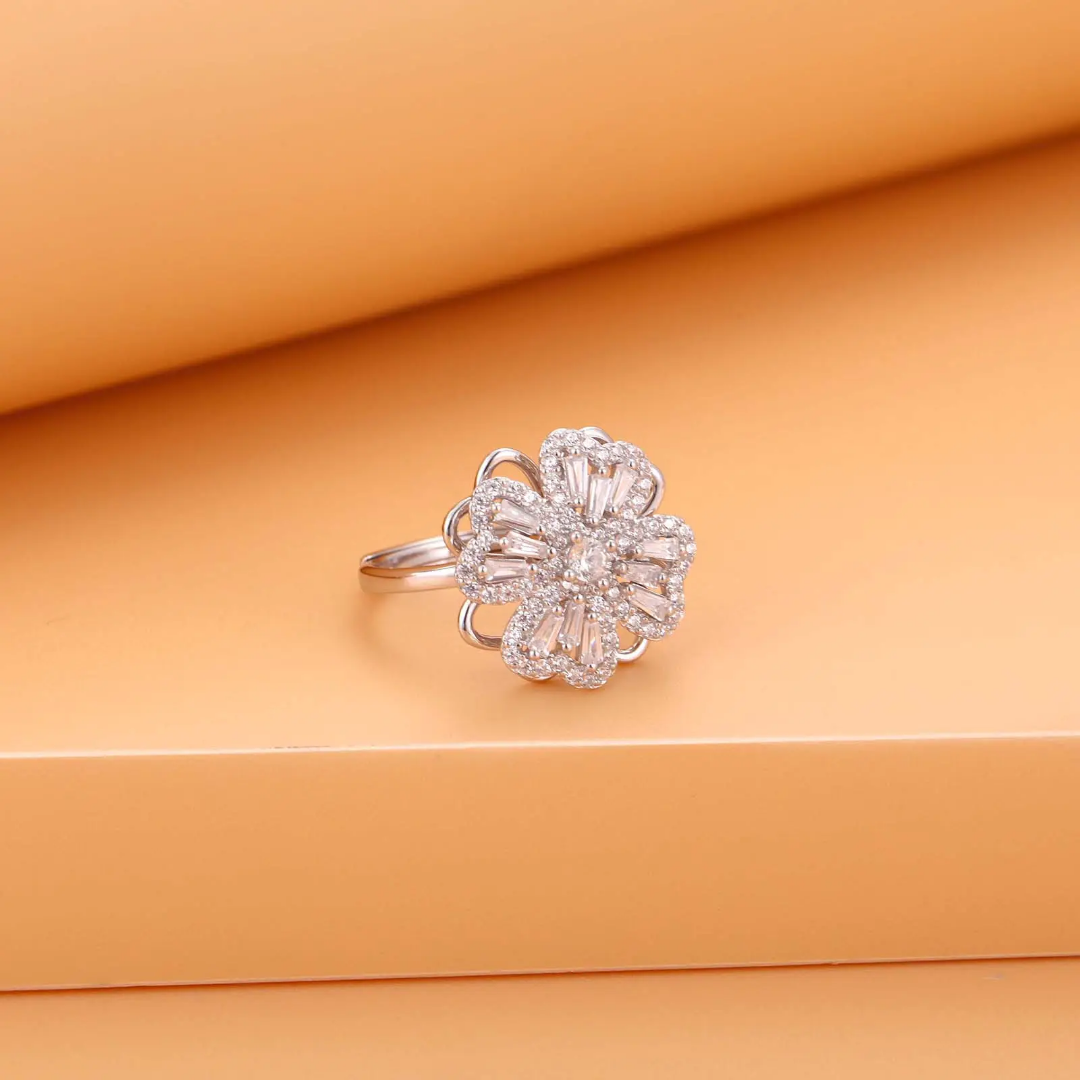 Silver flower-shaped ring on an orange fabric background