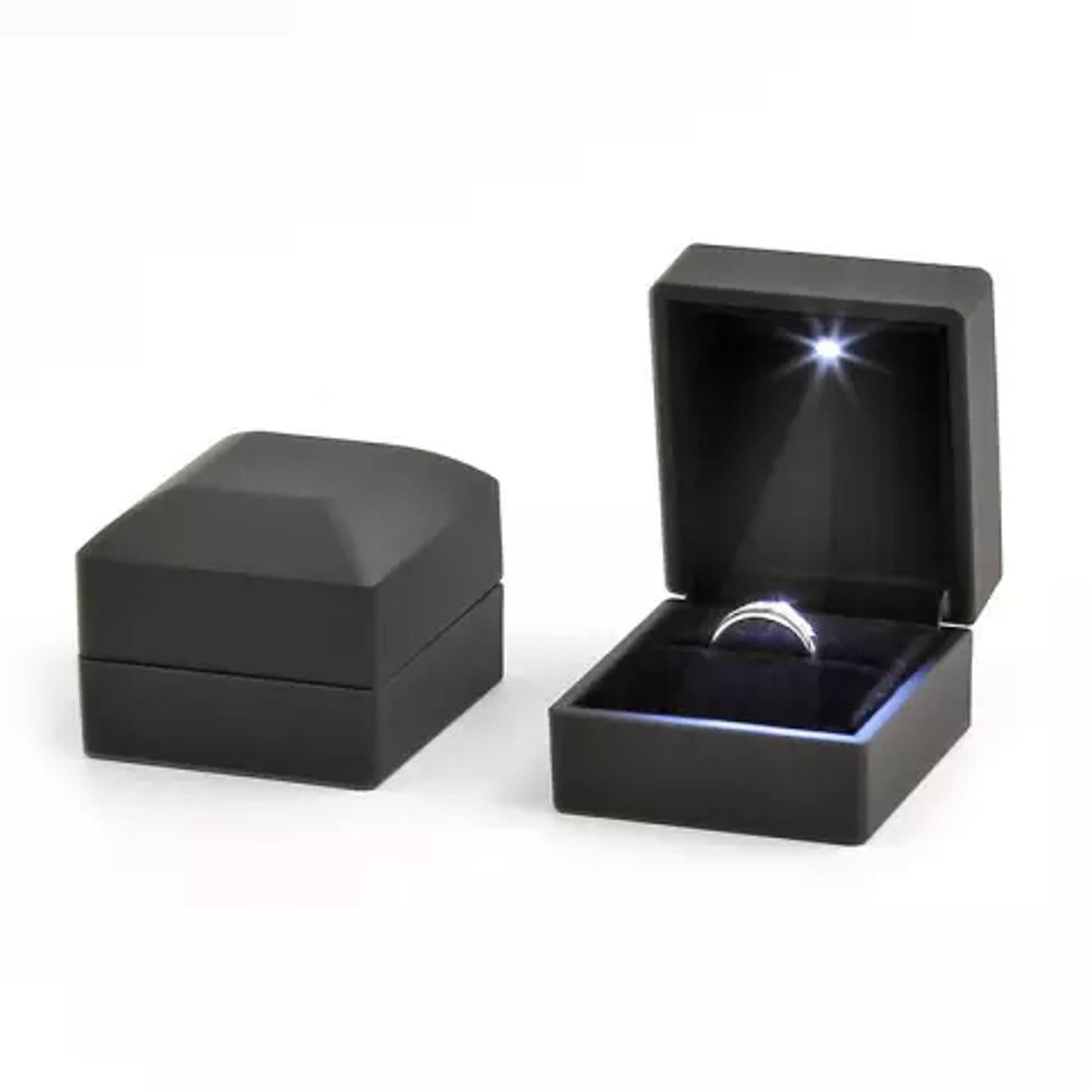 Black jewelry box with a ring inside on a white background