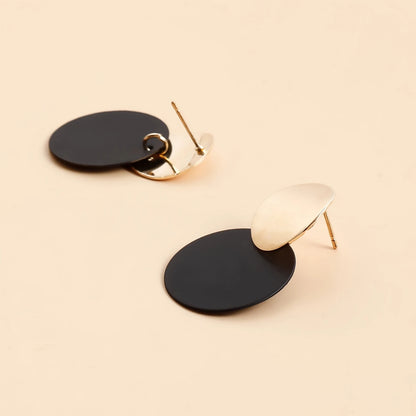 Black and gold earrings on a beige background - black and gold dangles for Pakistani girls