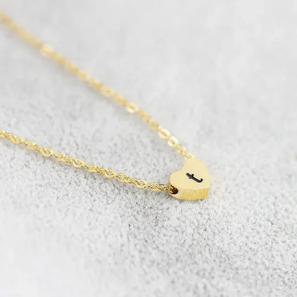 Gold necklace with a heart-shaped pendant on a light gray background - Affordbale artificial jewellery in pakistan