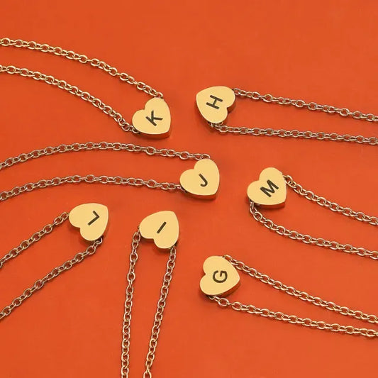 Gold necklaces with heart-shaped pendants on an orange background - Affordbale artificial jewellery in pakistan