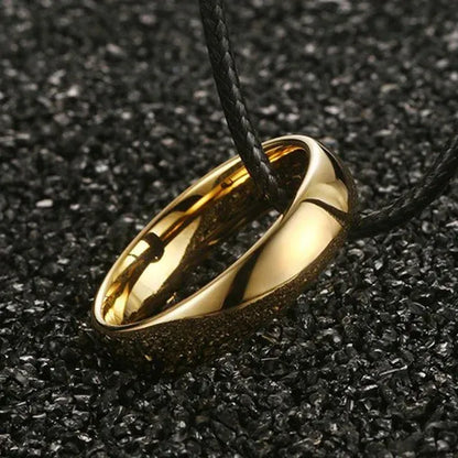 Gold ring pendant on a black cord against a dark textured background - Affordable artifiial jewellery in pakistan