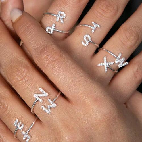 Radiant Initial Rings in elegant gold and silver, featuring a stylish adjustable design for a personalized touch.