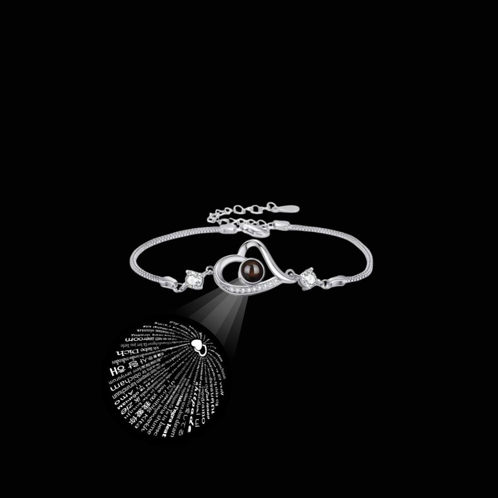 Silver bracelet with heart-shaped pendant on a black background