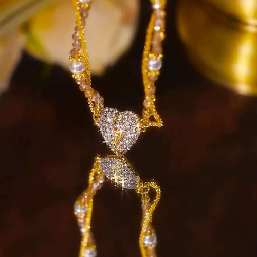 Gold necklace with heart-shaped pendant on a dark background