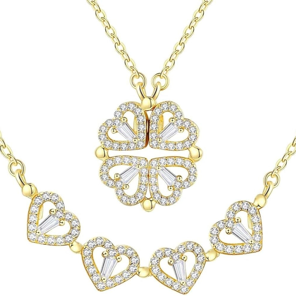 A gold-toned necklace featuring a heart-shaped pendant with a four leaf clover design, complemented by a sparkling zircon pendant, displayed against a white background. - Affordable artificial jewellery in pakistan