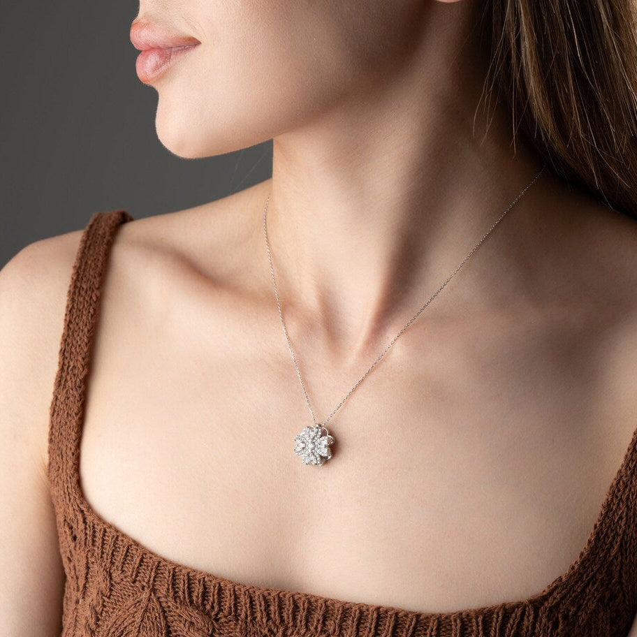 Woman wearing a delicate Lucky Clover Spinner Necklace with a floral pendant against a neutral background