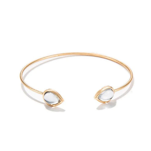 Gold bracelet with two white stones on a white background