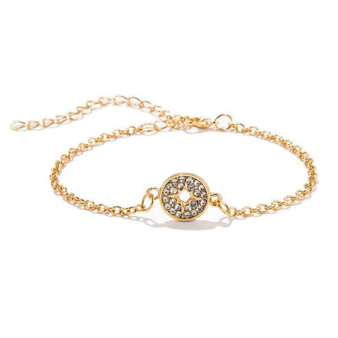 Gold bracelet with a decorative clasp on a white background