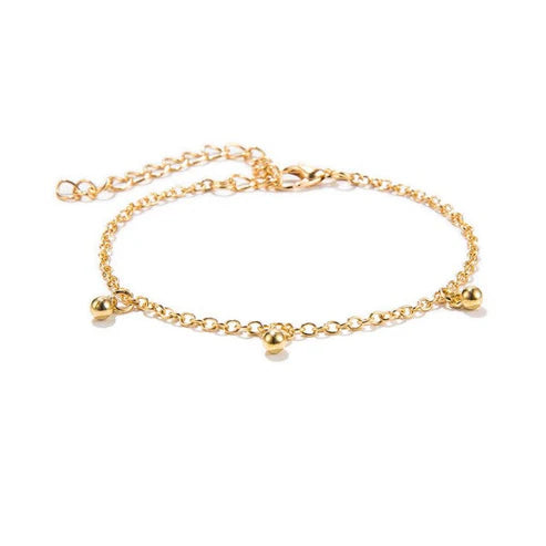 Gold anklet with small round beads on a white background