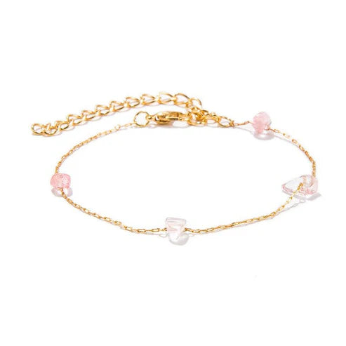 Gold anklet with pink and white beads on a white background