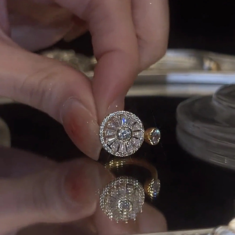 Close-up of a hand holding two decorative rings with intricate designs.