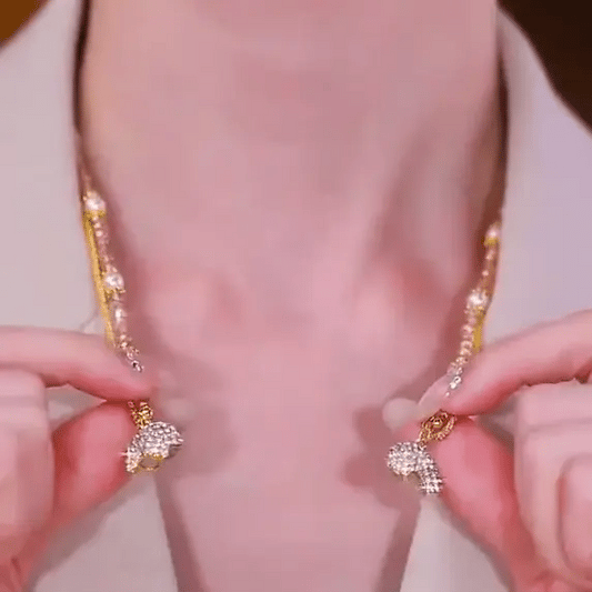 Close-up of a person wearing a gold necklace with diamond accents.