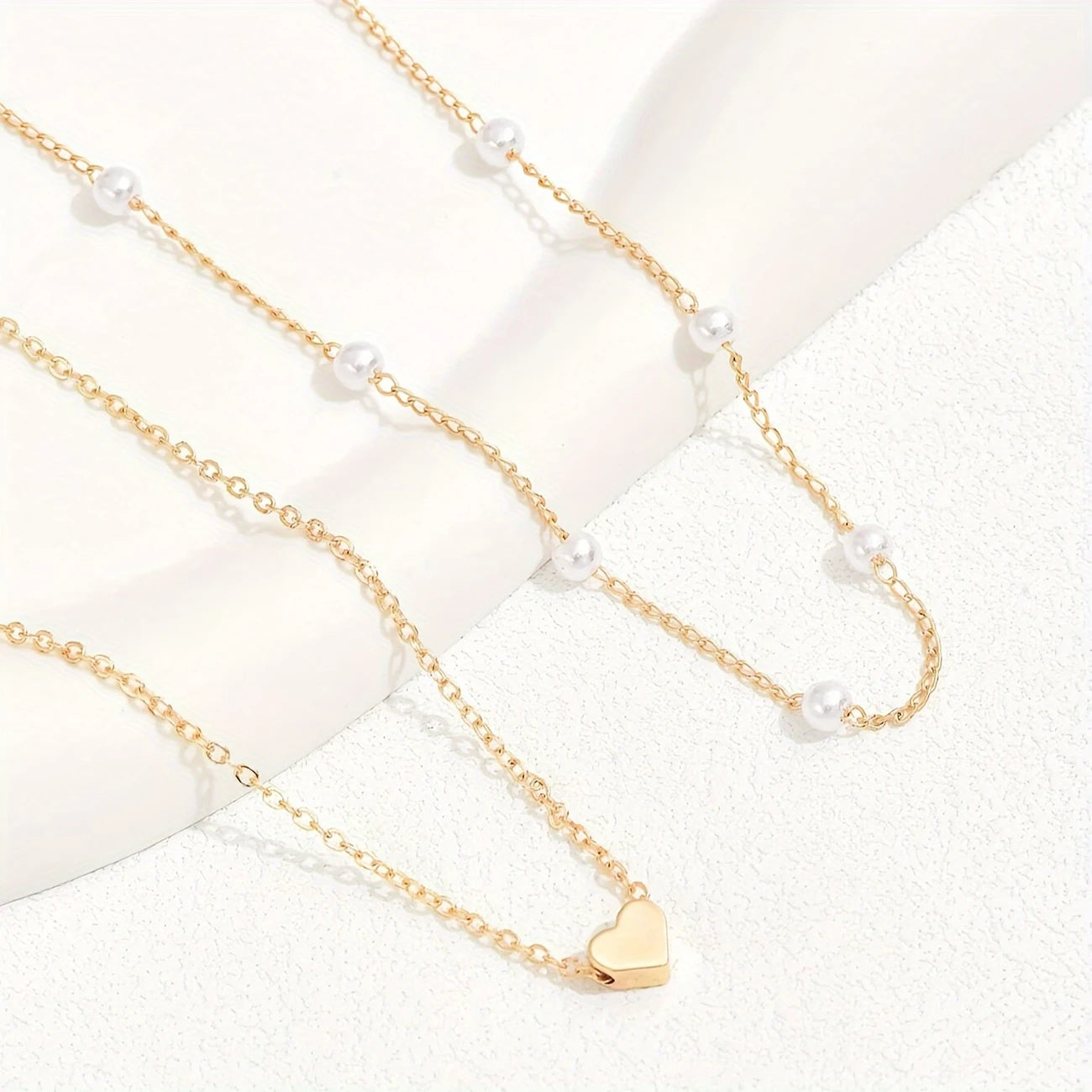 Gold necklace with heart pendant and pearl beads on a white background - Affordable Artificial jewellery in pakistan