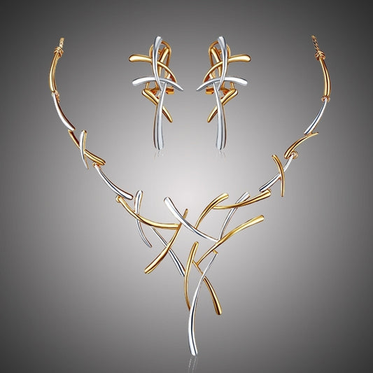 Jewelry set with gold and silver necklace and earrings on a gray background