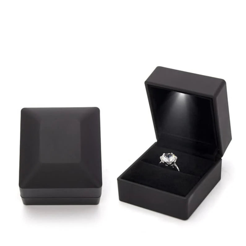 Black jewelry box with a ring inside on a white background
