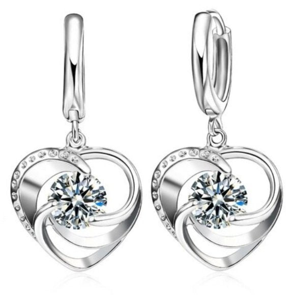 Silver heart-shaped earrings with clear gemstones on a white background