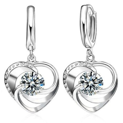Silver heart-shaped earrings with clear gemstones on a white background