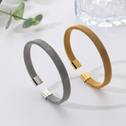 Two mesh bracelets, one silver and one gold, on a light background.