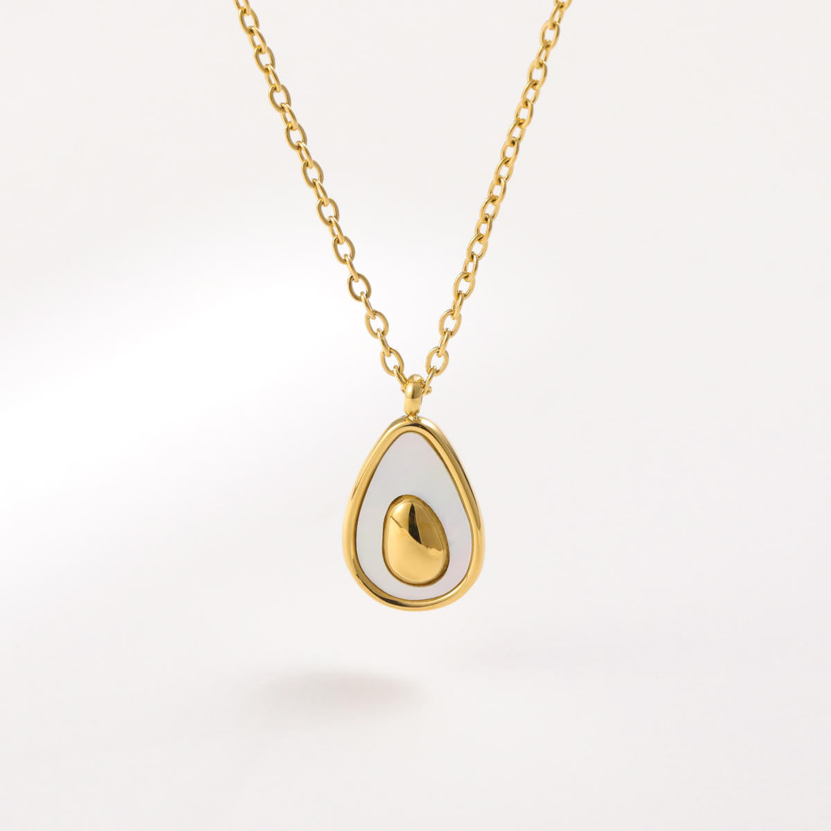 Gold necklace with a teardrop-shaped pendant on a white background