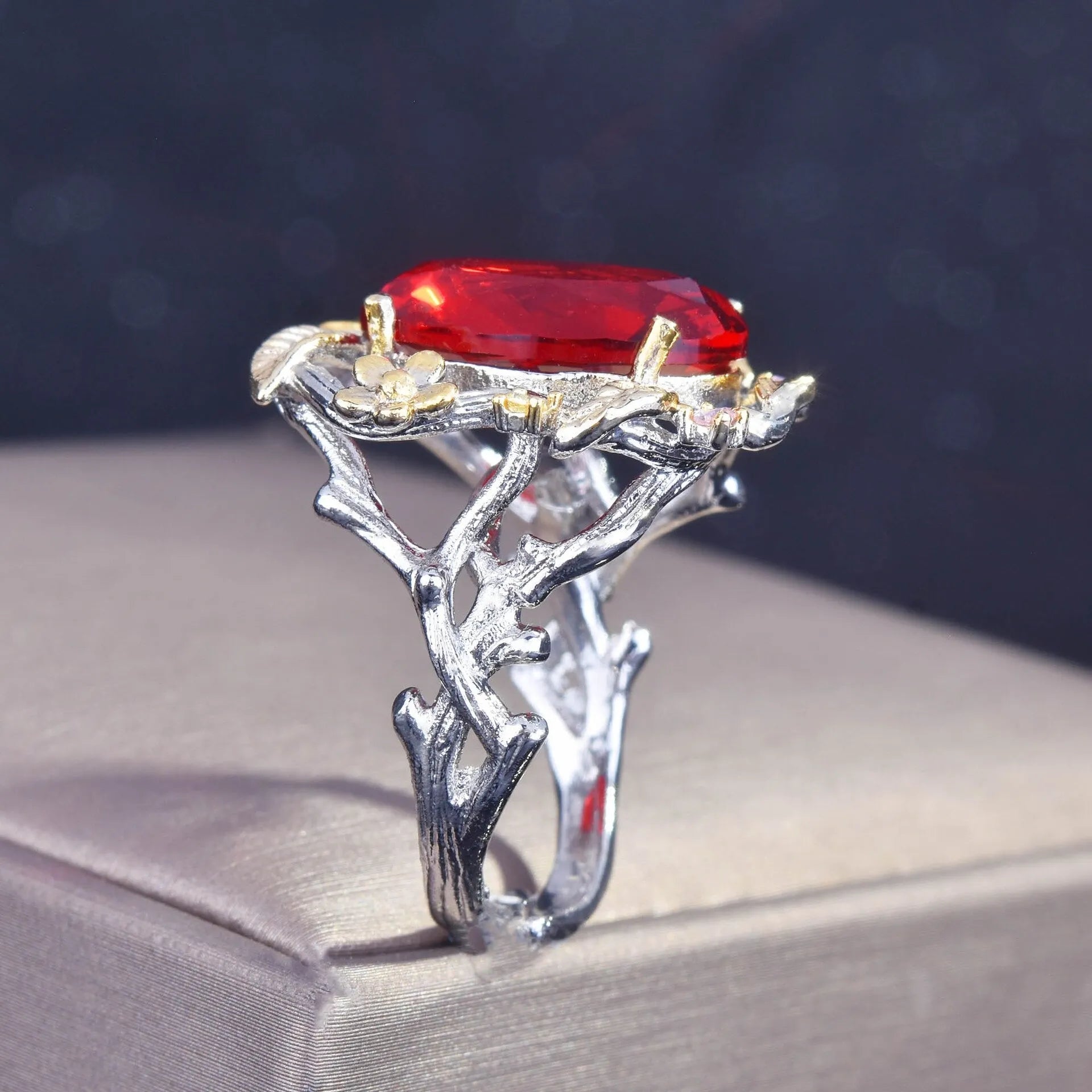 Side view of vintage silver leaf ring with adjustable band and red gemstone