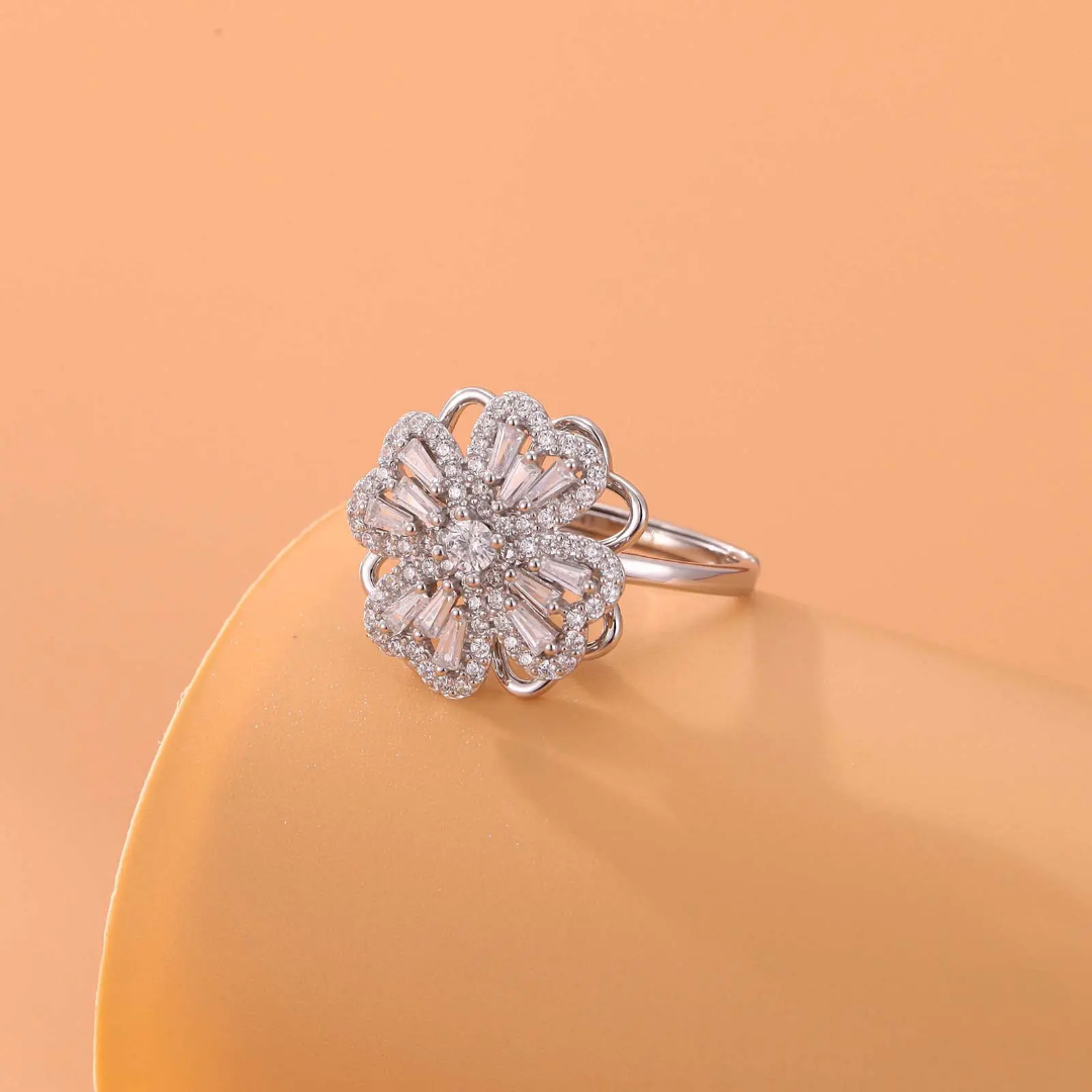 Silver ring with floral design on a peach-colored background
