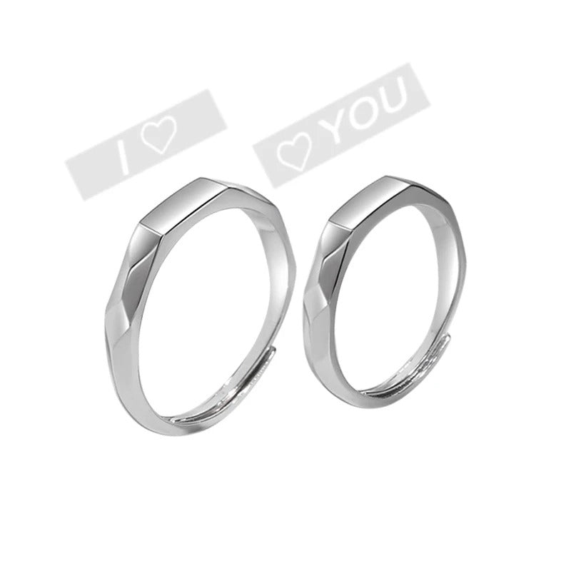 Two silver rings on a white background with 'I LOVE YOU' text overlay.