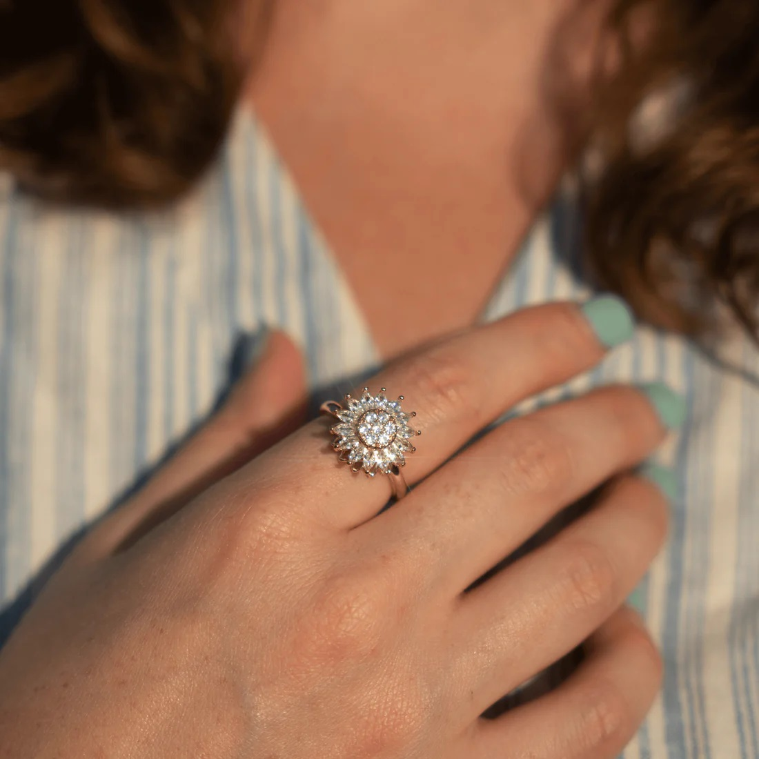 Hand wearing a gold color sunflower style ring
