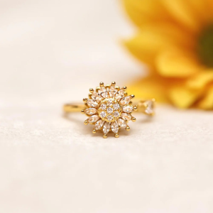 sunflower spinning Gold ring with diamond accents on a light background