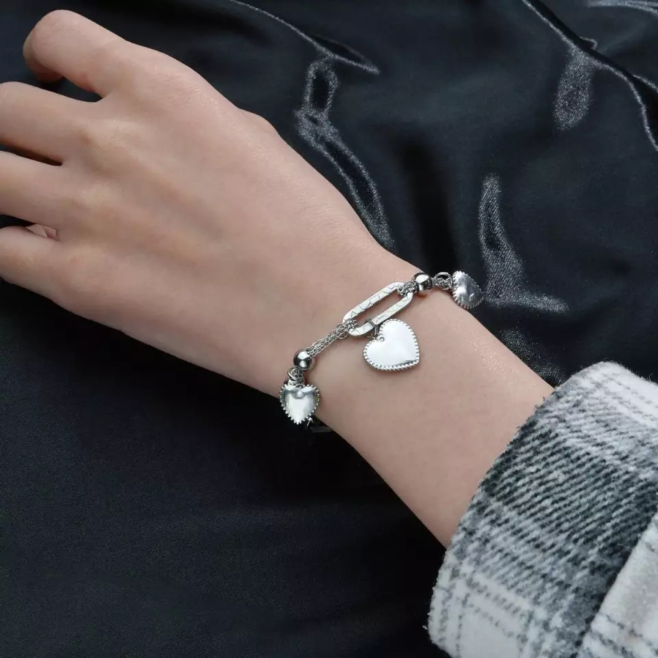 Woman wearing heart charm bracelet Pakistan daily wear jewelry